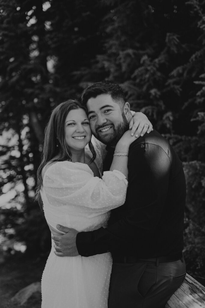 Black and white photo of couple in an embrace and looking at the camera during their engagement photos at Mount Rainier National Park