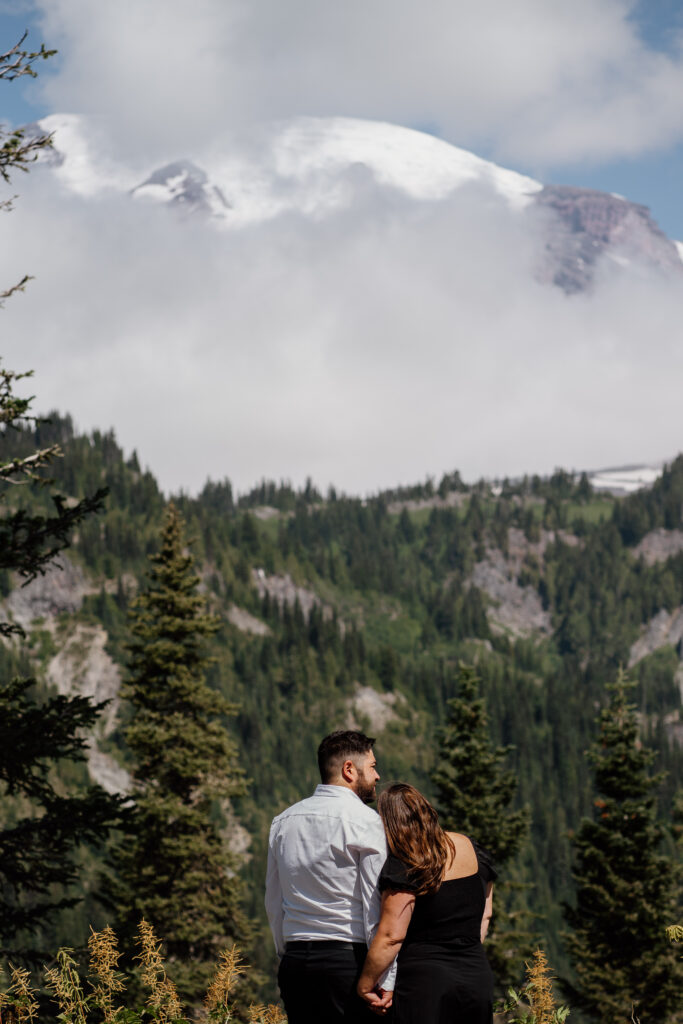 Couple looking up at Mount Rainier during their engagement session