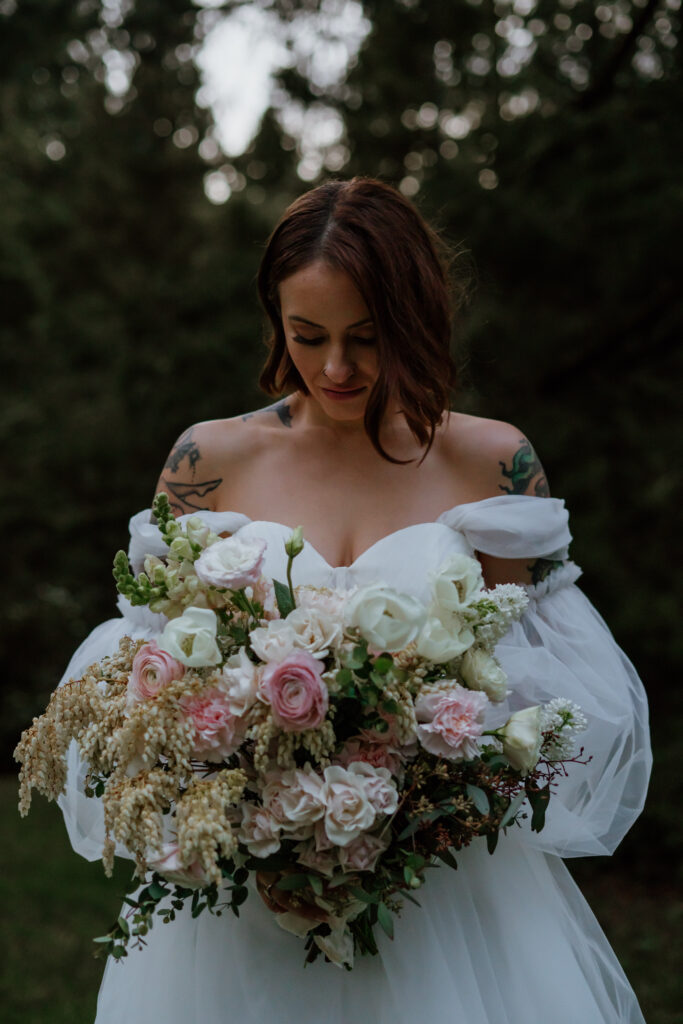 Photo of bride holding boho bridal bouquet during a twilight inspired elopement at Hoyt Arboretum in Oregon.