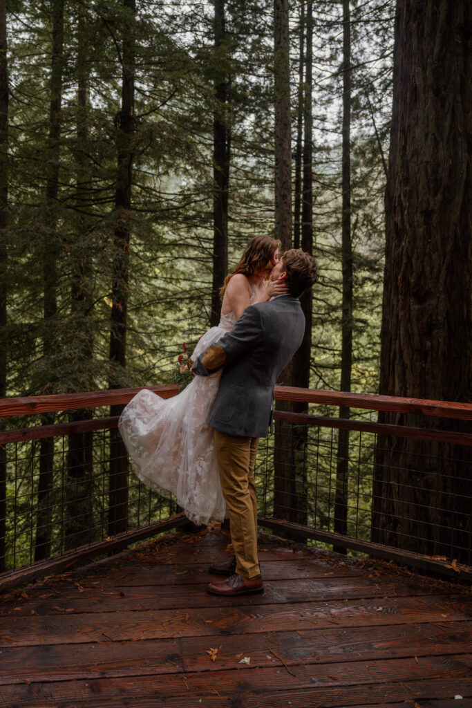 Groom lifting bride and kissing on the Redwood Deck during their elopement at Hoyt Arboretum in Portland, Oregon.