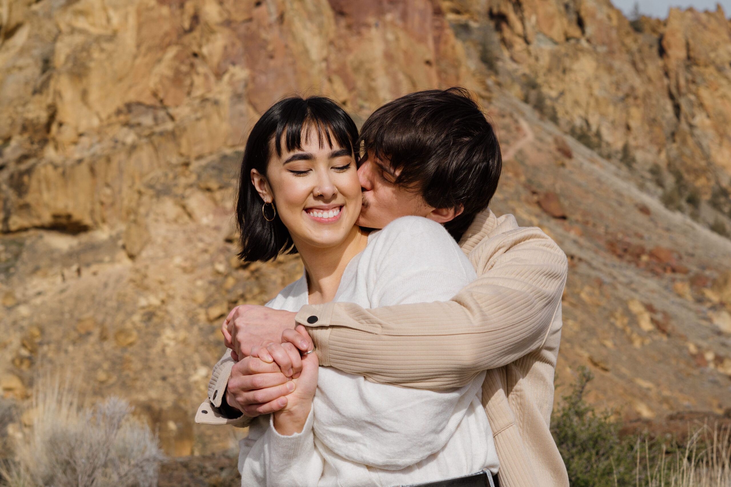 Couple hugging at Smith Rock State Park during their adventure photo session.