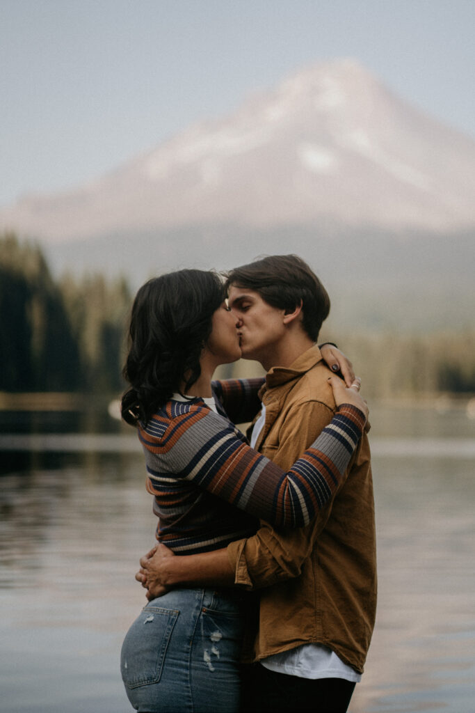 Couple kissing with Mount Hood towering in the background during their engagement photos.