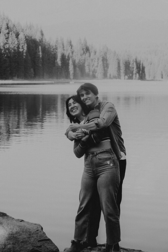 Couple hugging standing in front of Trillium Lake in Oregon.