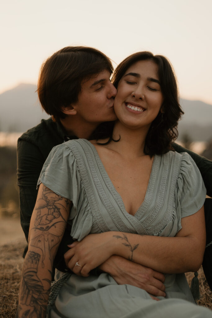 Couple kissing with Columbia River Gorge in the background during sunset.