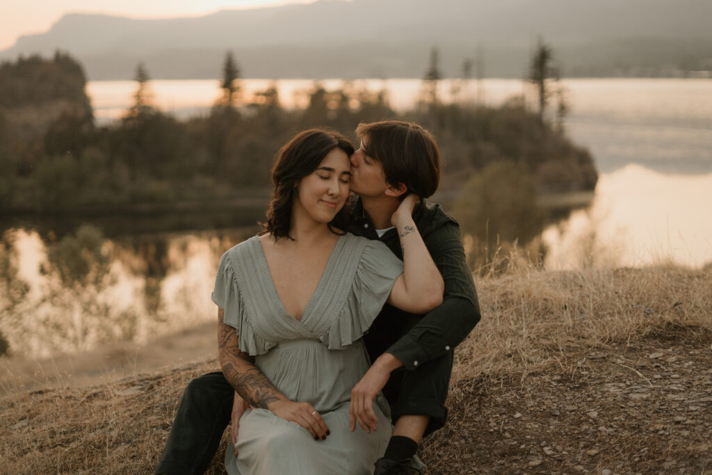 Couple sitting with Columbia River Gorge in the background during their engagement photos.