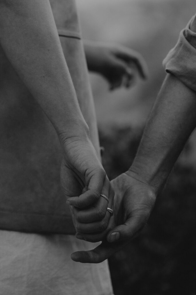 Close up of a couple holding hands during their engagement photos in Yosemite National Park.