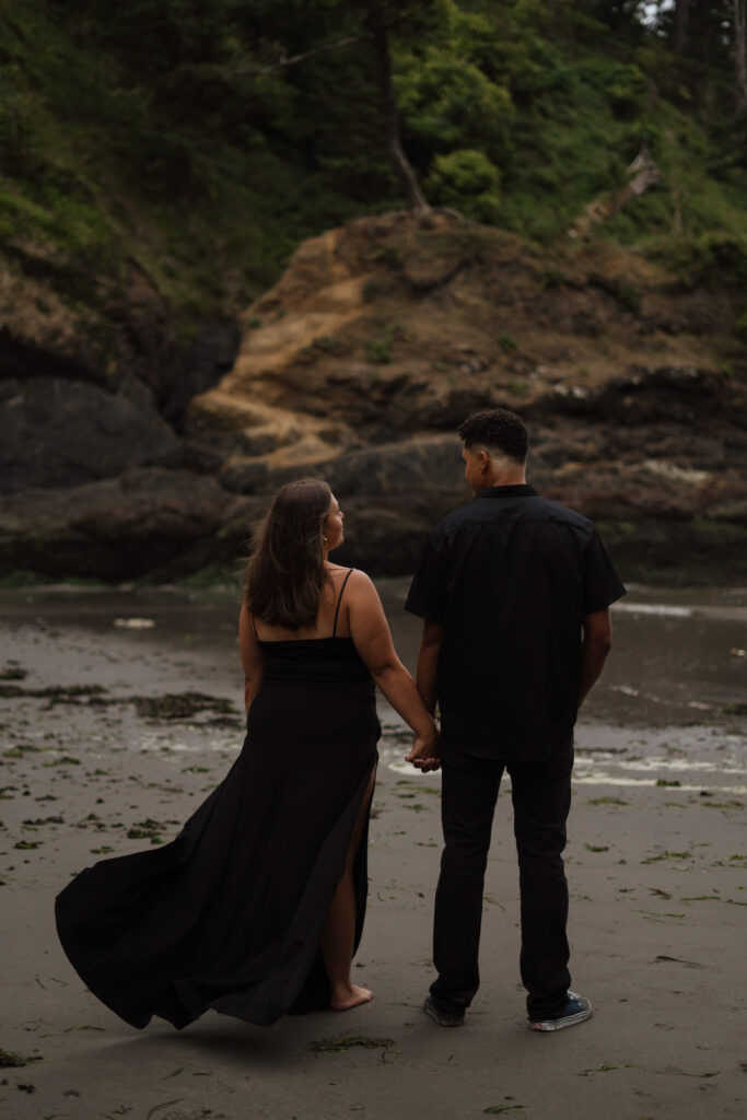 Couple holding hands during their engagement session at Cape Disappointment State park on the Washington Coast.