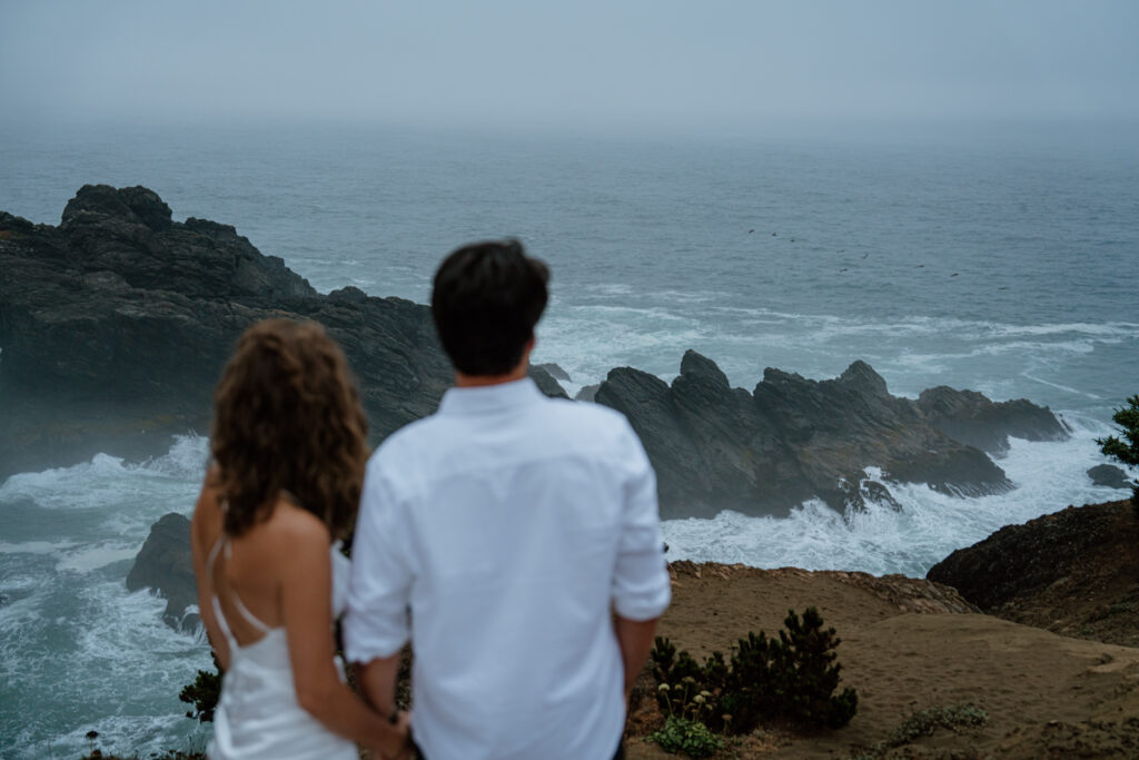 Couple looking out over jagged Oregon Coast Coastline during their Oregon Coast Elopement in the Samuel H Boardman Scenic Corridor.
