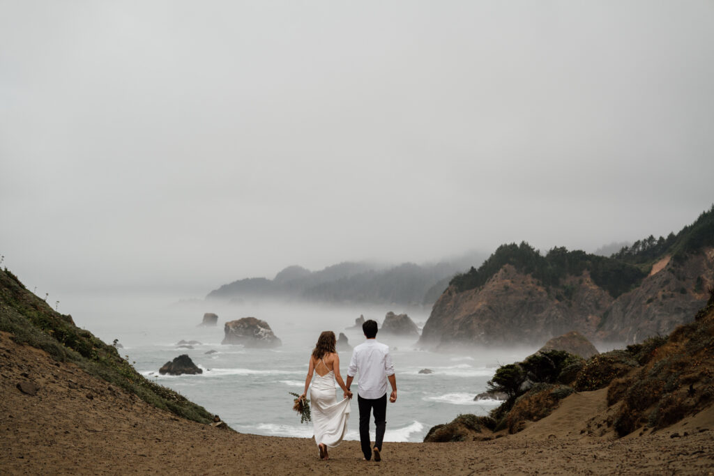 Couple walking in their wedding attire during their Samuel H Boardman hiking elopement in Brookings, Oregon.