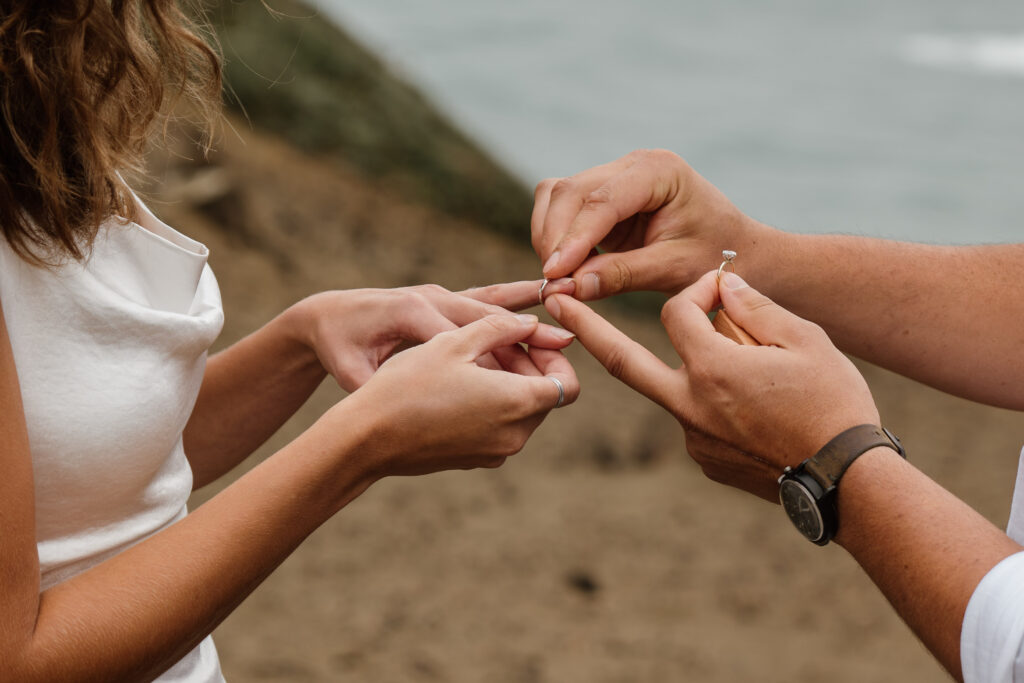 Close up of couple exchanging rings during their Samuel H Boardman Adventure Elopement.