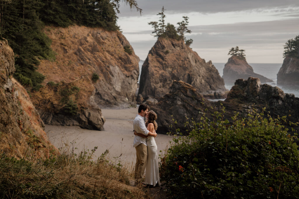 Bride and Groom kissing with Secret Beach in the background during their Elopement outside of Brookings, Oregon.