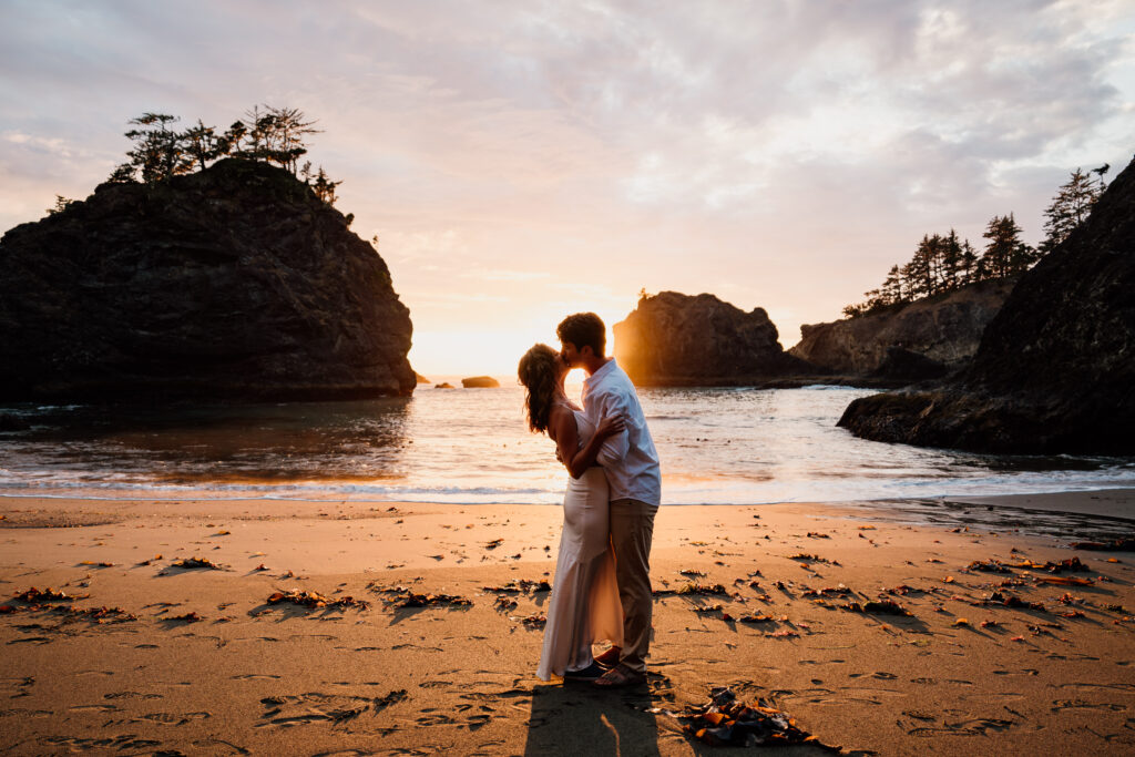 Bride and Groom kissing with the sunset in the background at Secret Beach near Brookings, Oregon during their Adventure Elopement