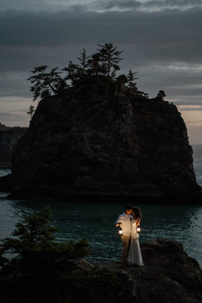 Wedding Couple holding lanterns along the Oregon Coast during their hiking Elopement.
