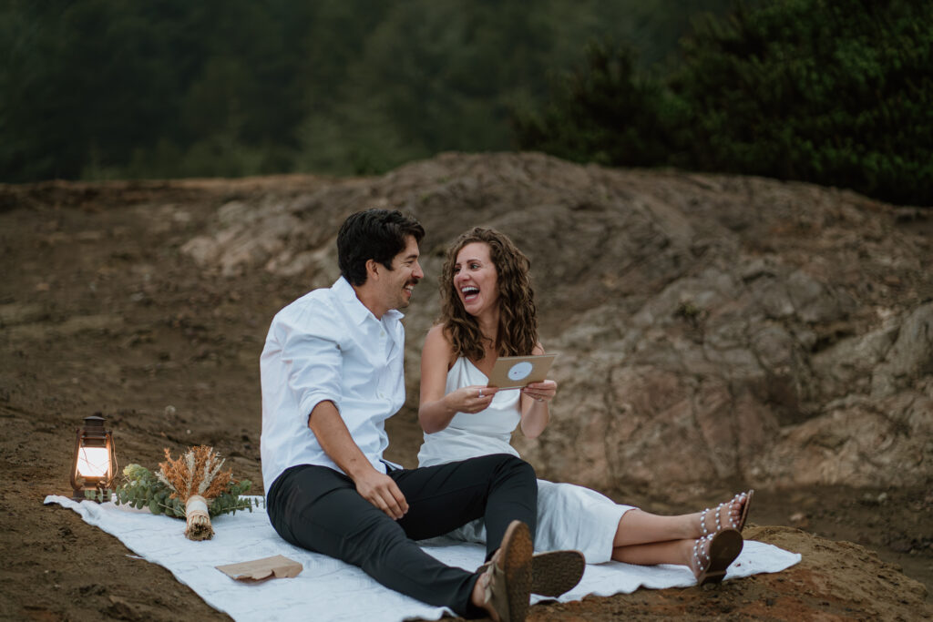 Bridal Couple laughing while reading a letter during their Oregon Coast Adventure Elopement in the Samuel H Boardman Scenic Corridor.