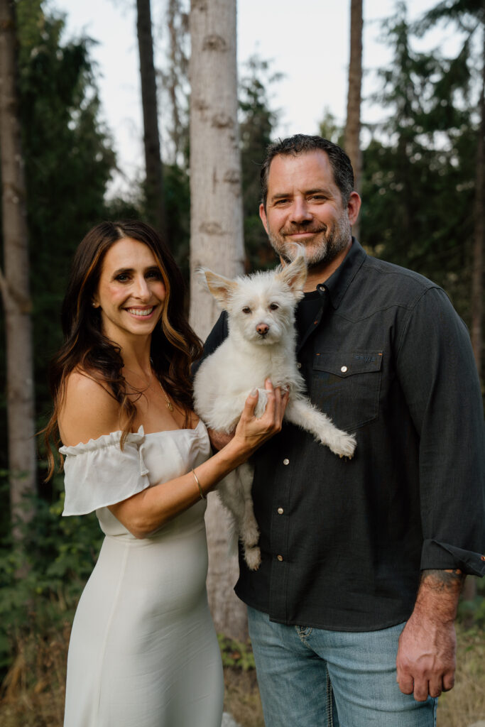 Couple holding their dog in dressed up attire during their engagement session.