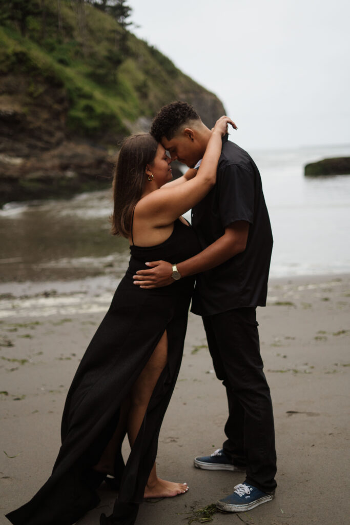 Couple standing forehead to forehead during their Washington Coast engagement photos.