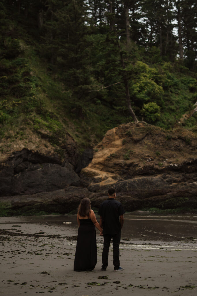 Couple holding hands and looking out at the scenery on the Washington Coast.