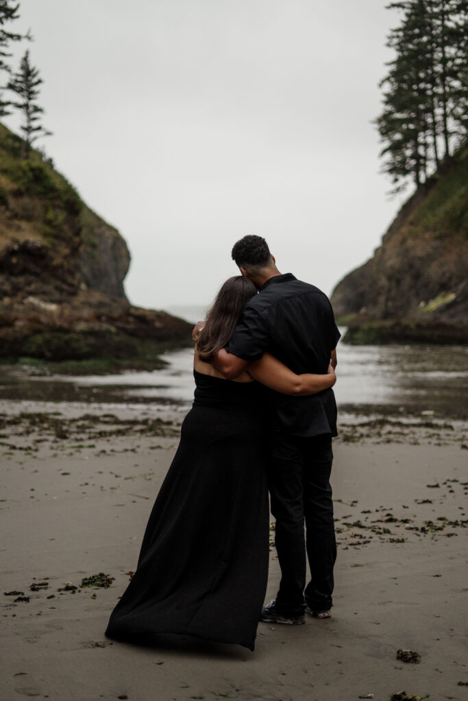 Couple hugging and looking out at the Washington Coast.