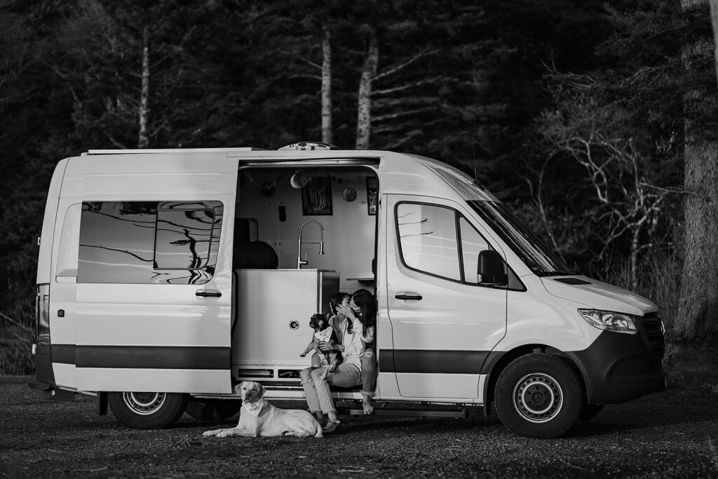 Couple sits in their van with their two pups