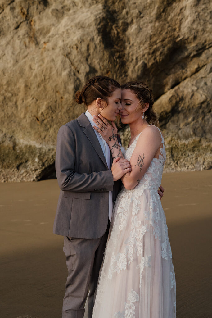 bride and bride snuggle up on the beach