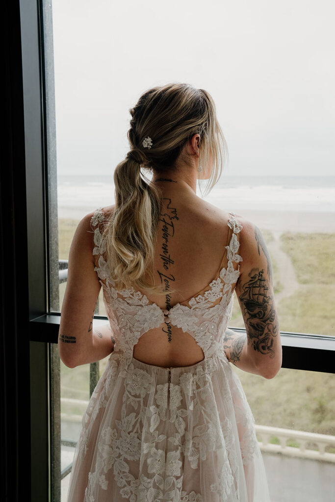 Bride looking out the window of their beach condo