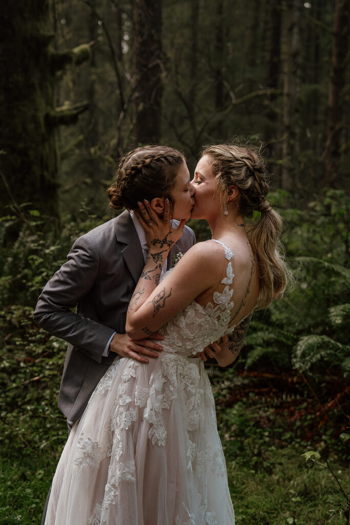 Brides kissing in Ecola State Park forest