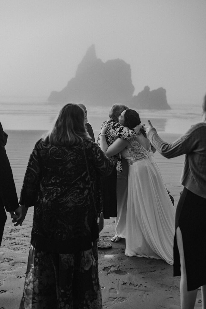 Couple hugs their family and friends after their beach micro wedding ceremony 