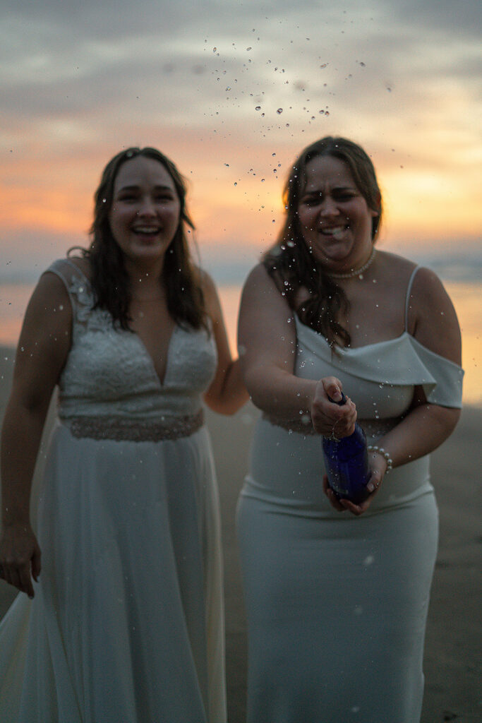 Couple pops champagne on the beach to celebrate their micro wedding