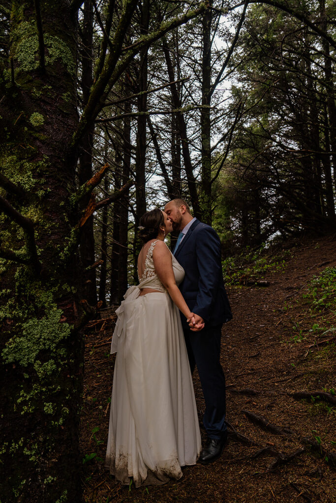 Bride and groom kiss in an Oregon forest