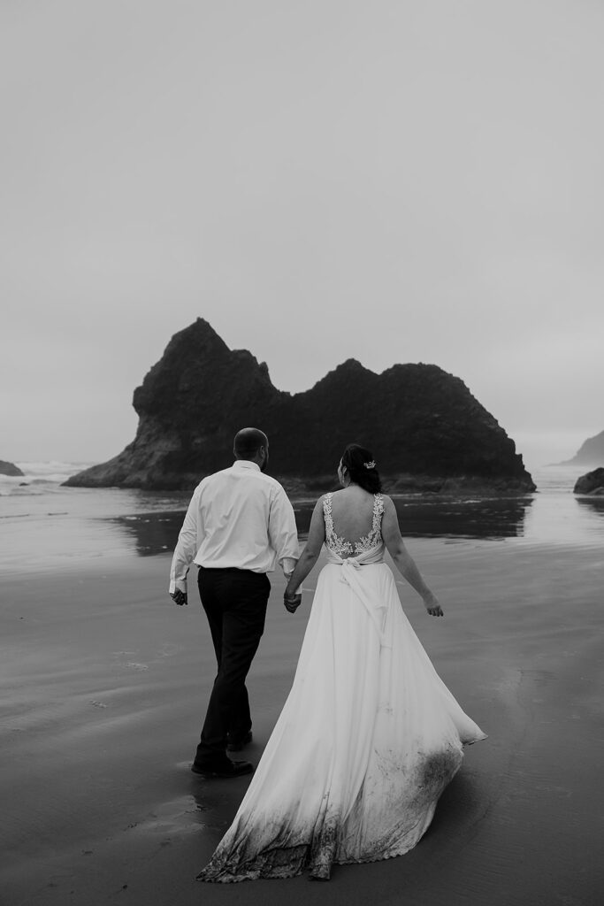 Couple walking along Arcadia Beach after their elopement ceremony