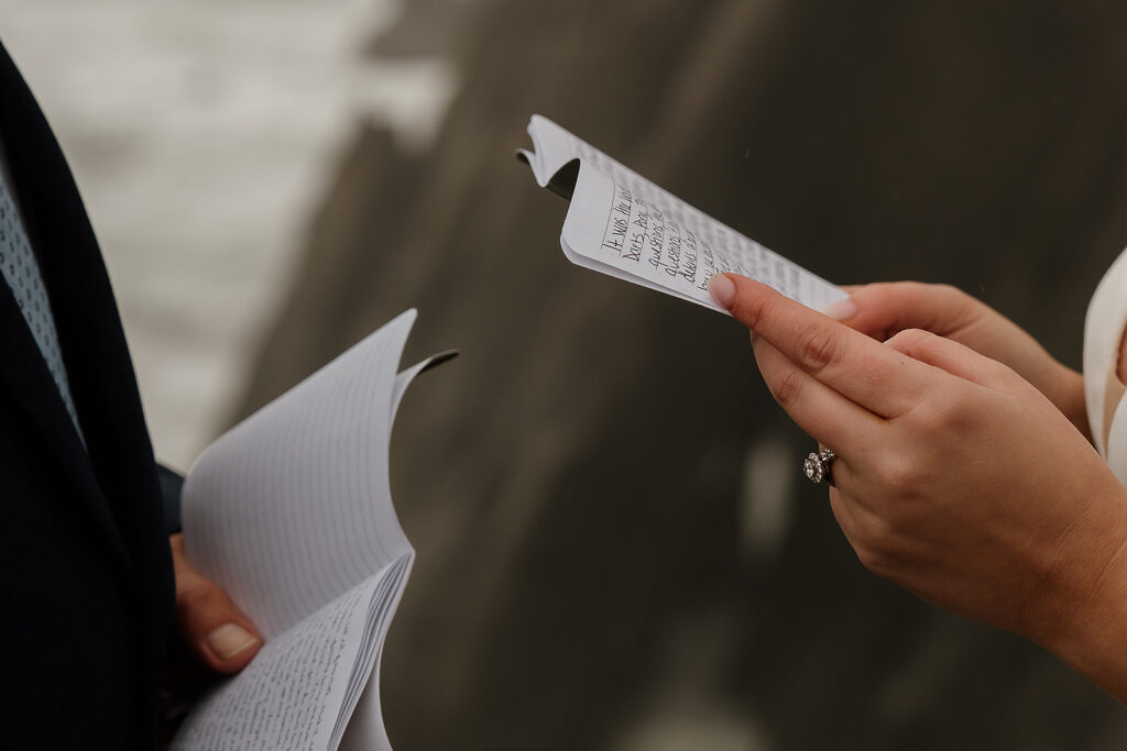 Bride and groom reading from their handwritten vow books