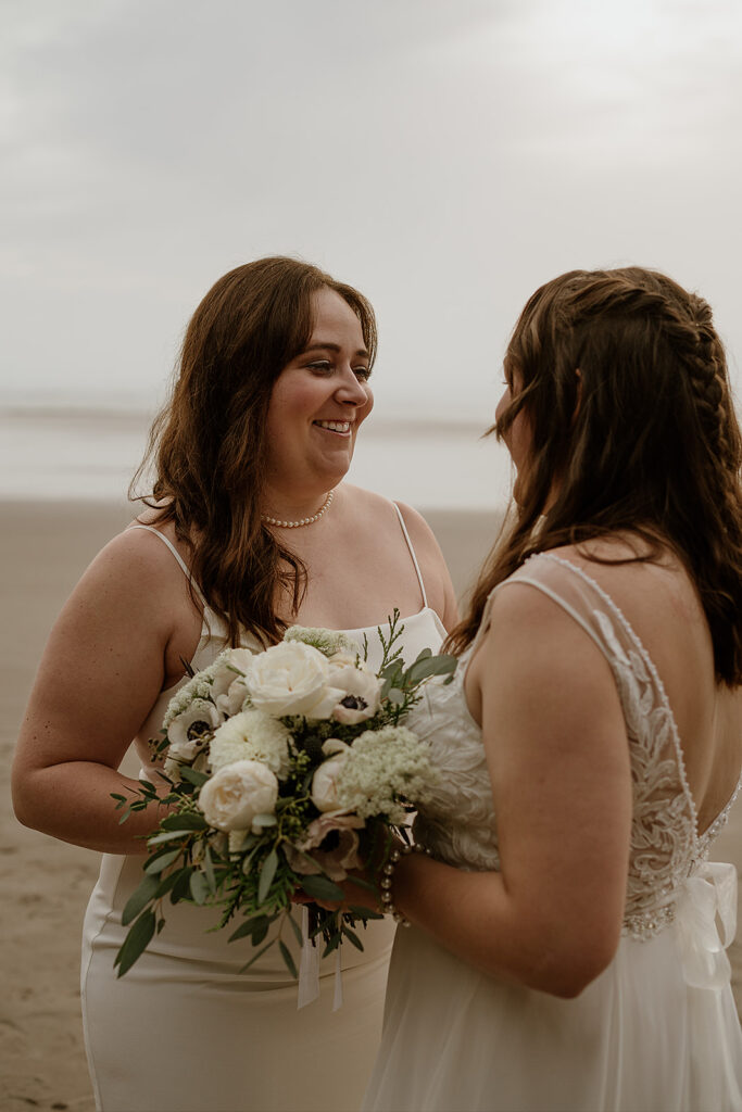 Bride and bride smile at each other at sunset