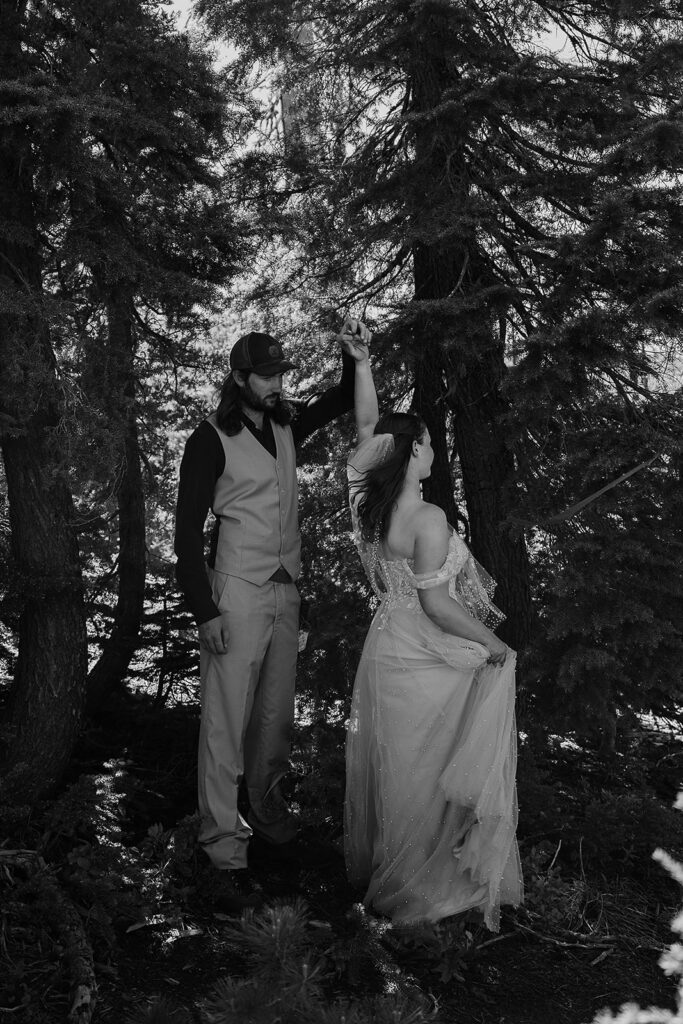 Bride and groom dance in the forest surrounded by evergreen trees