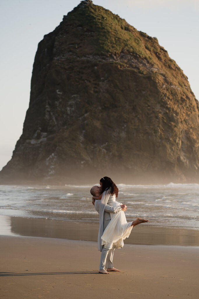 Couple dancing around on the shore during their Cannon Beach bridal portraits.