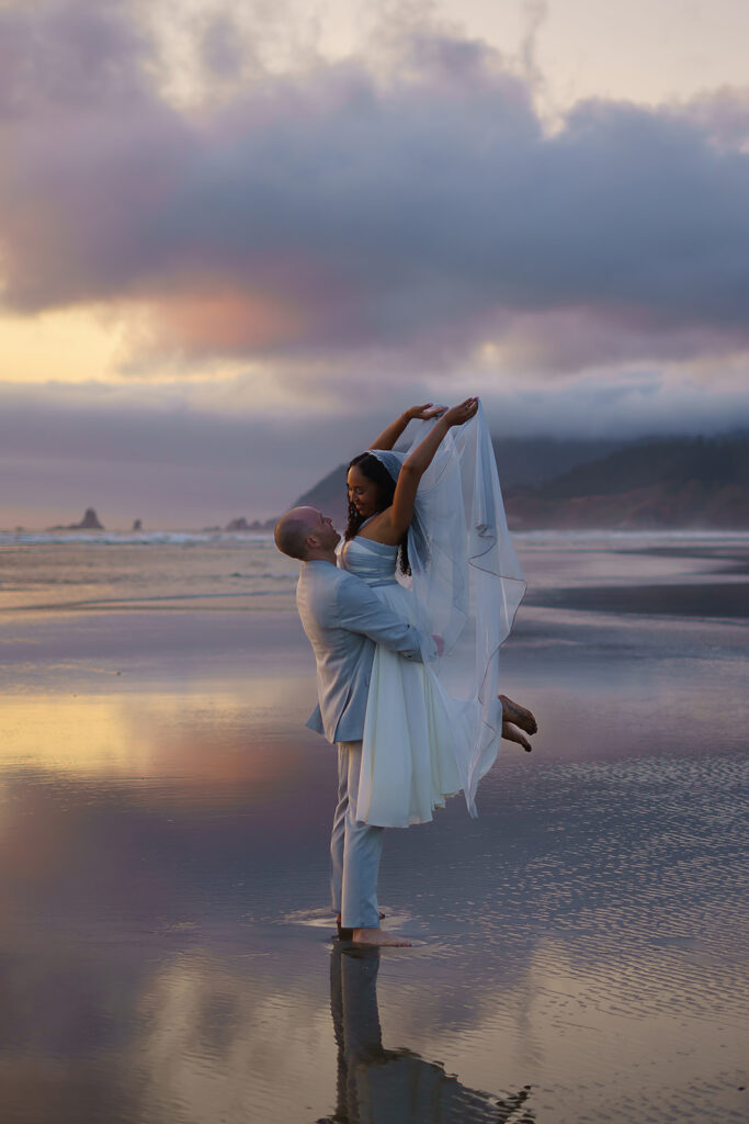 Couple takes an editorial style shot as bride throws up her dress during their Cannon Beach bridal portraits.