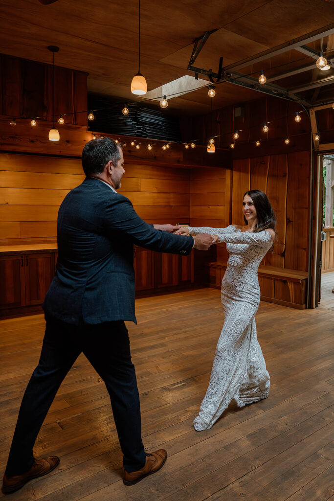 Bride and grooms fun first dance in the Treehouse Point reception area