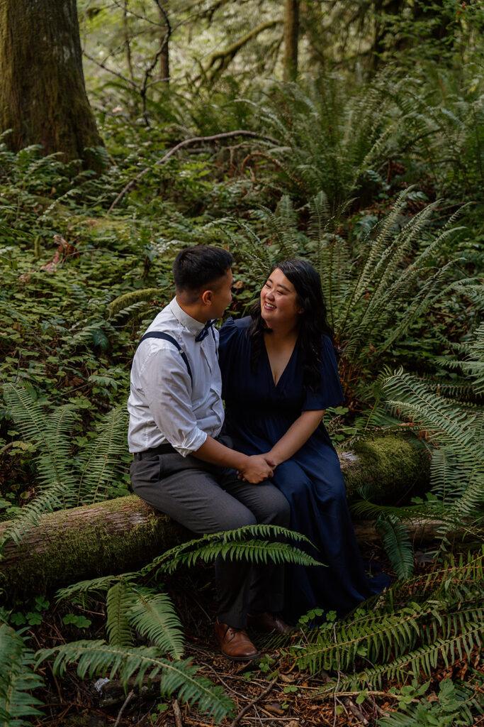 Couple sits in the mossy foliage at Wildwood Recreation Site for their outdoor photoshoot