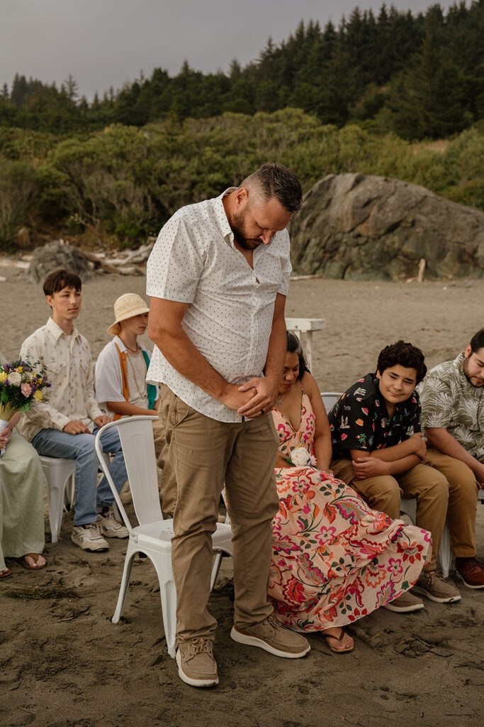 Wedding guests pray over the bride and grooms rings during their Oregon micro wedding ceremony