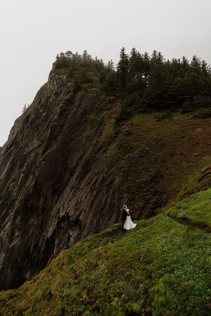 Couple standing on cliffside during their Oregon Coast Elopement.