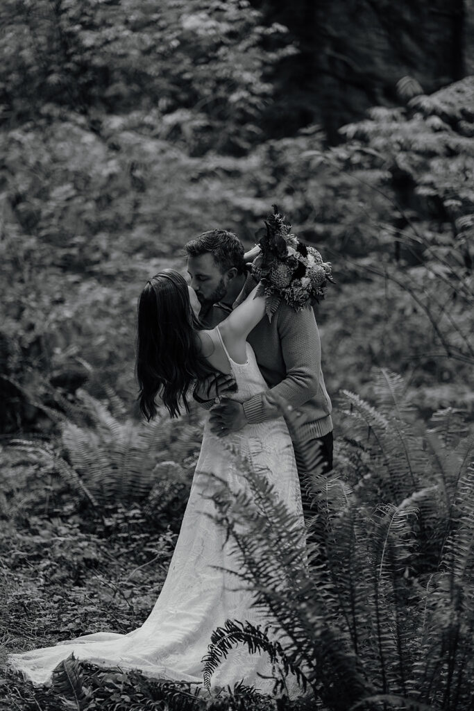 Bride and groom stand in the moody forest of Ecola State Park