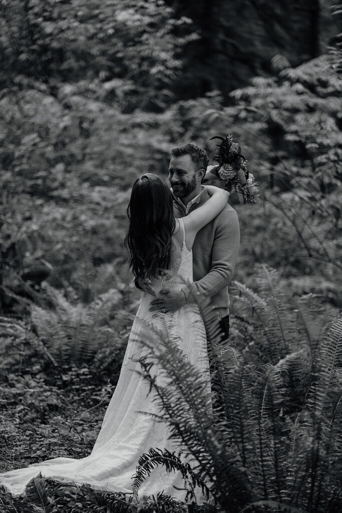 Bride and groom stand in the moody forest of Ecola State Park