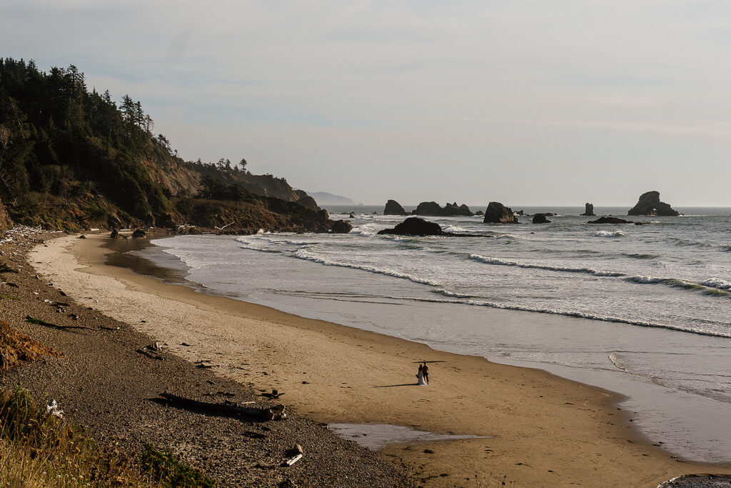 Couple walks along Indian Beach after their elopement ceremony