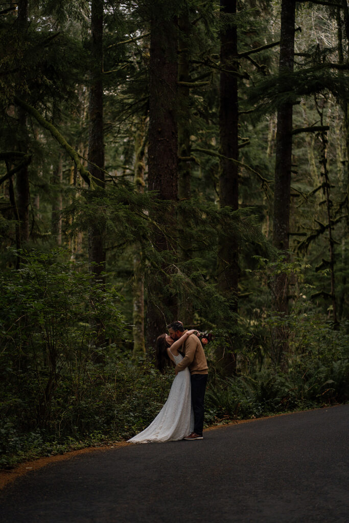 Bride and groom walk through the moody forest of Ecola State Park