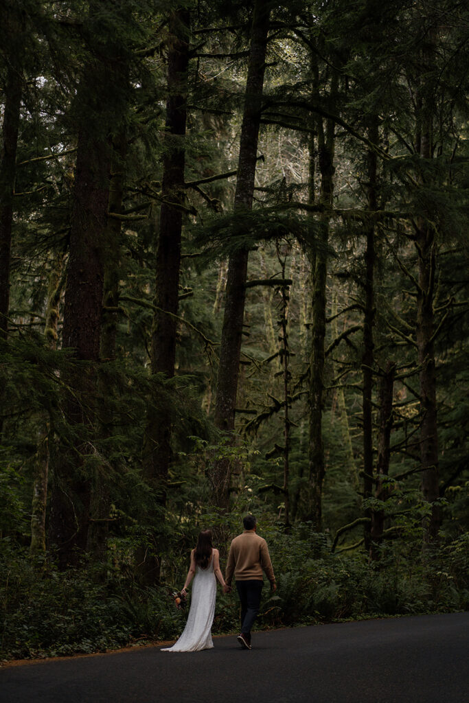 Bride and groom walk through the moody forest of Ecola State Park