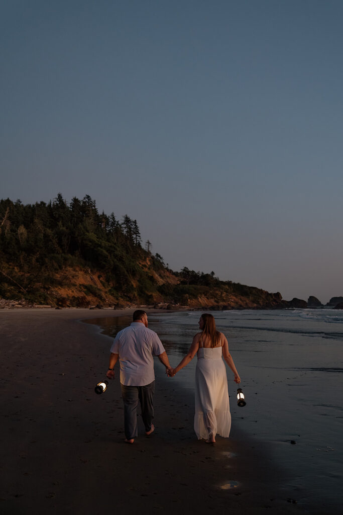 Beach couples photos with lanterns at dusk