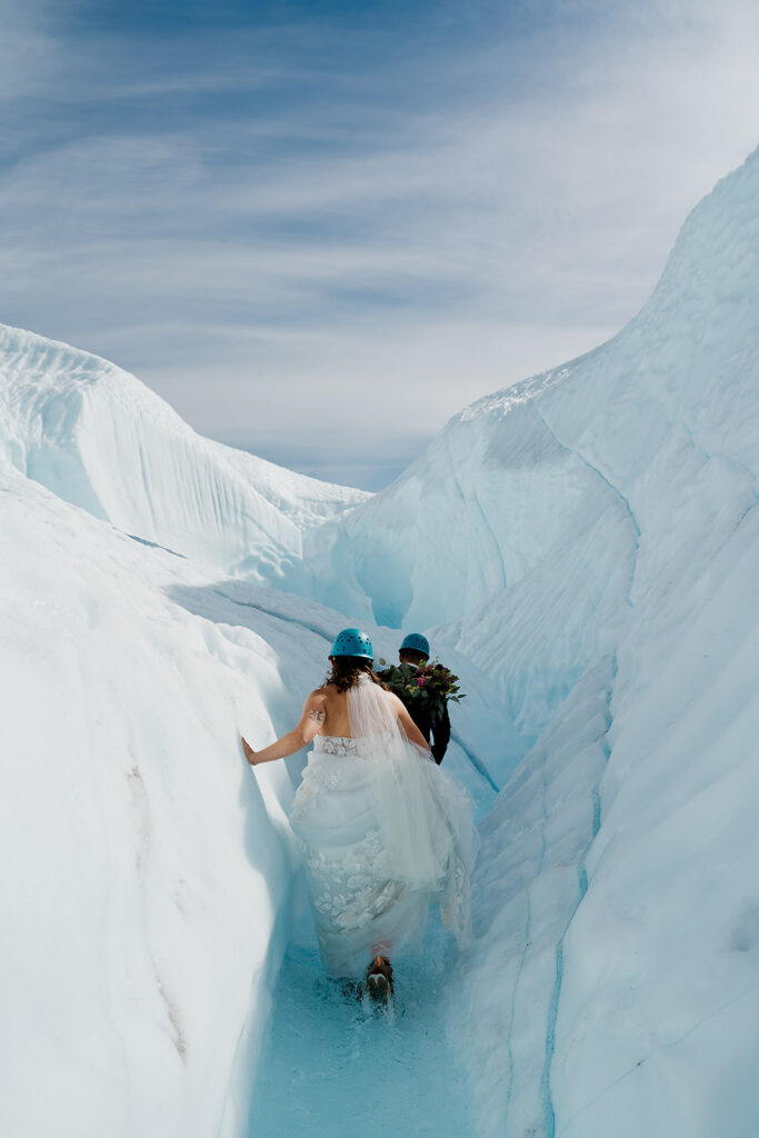 Bride and groom hike to a glacial waterfall in Alaska