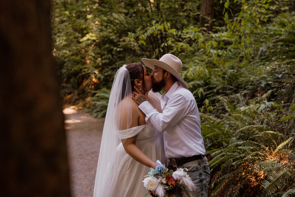 Bride and groom kiss surrounded by Ferns and redwoods at Hoyt Arboretum 