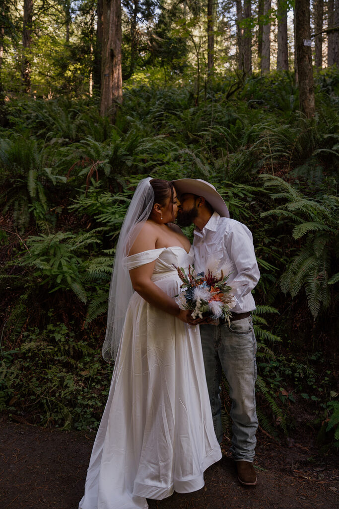 Bride and groom kiss surrounded by Ferns and redwoods at Hoyt Arboretum 
