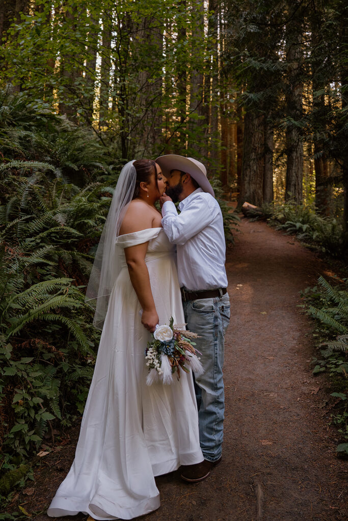 Bride and groom kiss surrounded by Ferns and redwoods at Hoyt Arboretum 
