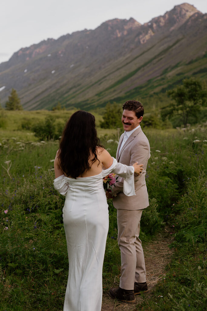 Intimate first look between bride and groom in the mountains during a summer Alaska elopement